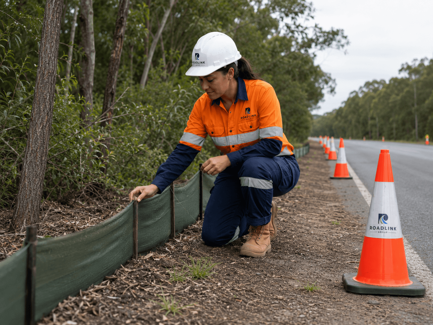 Roadlink Group worker checking roadside environmental protection beside traffic cones