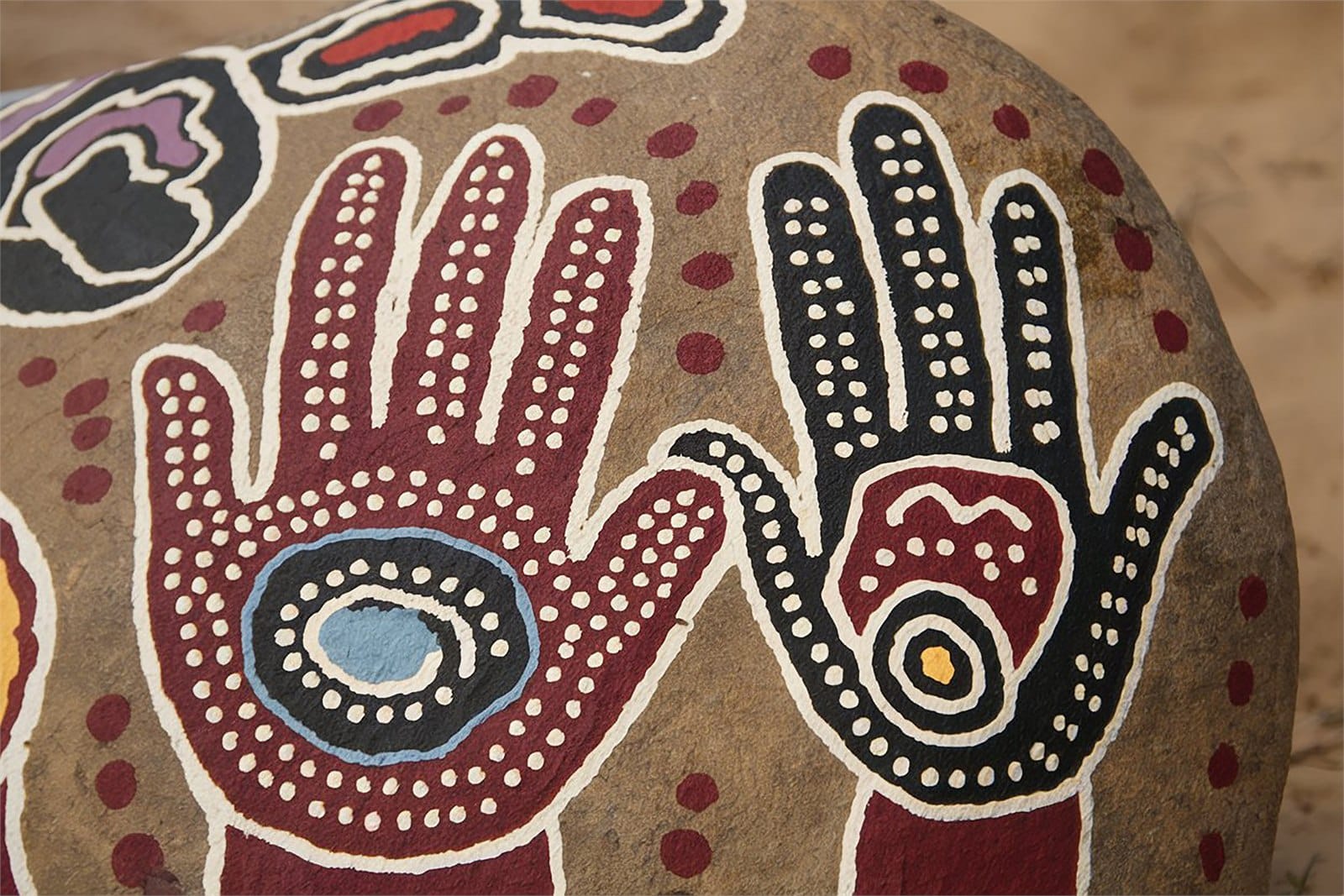 Close-up of painted hand motifs on an artwork